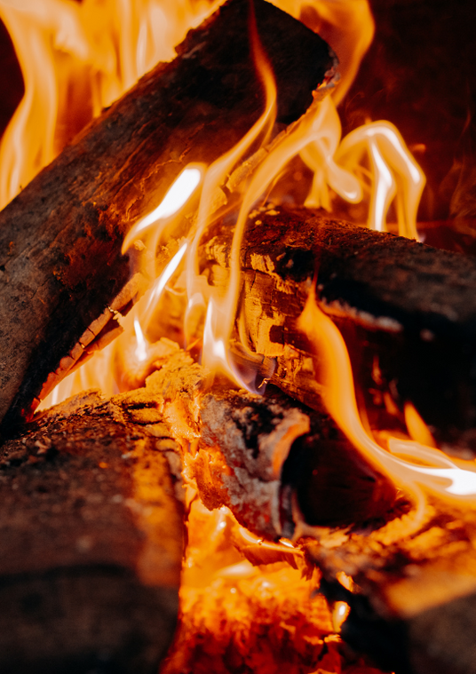 Een intieme close-up van een knetterend haardvuur, gevoed door prachtig haardhout dat zorgt voor een magische ambiance.